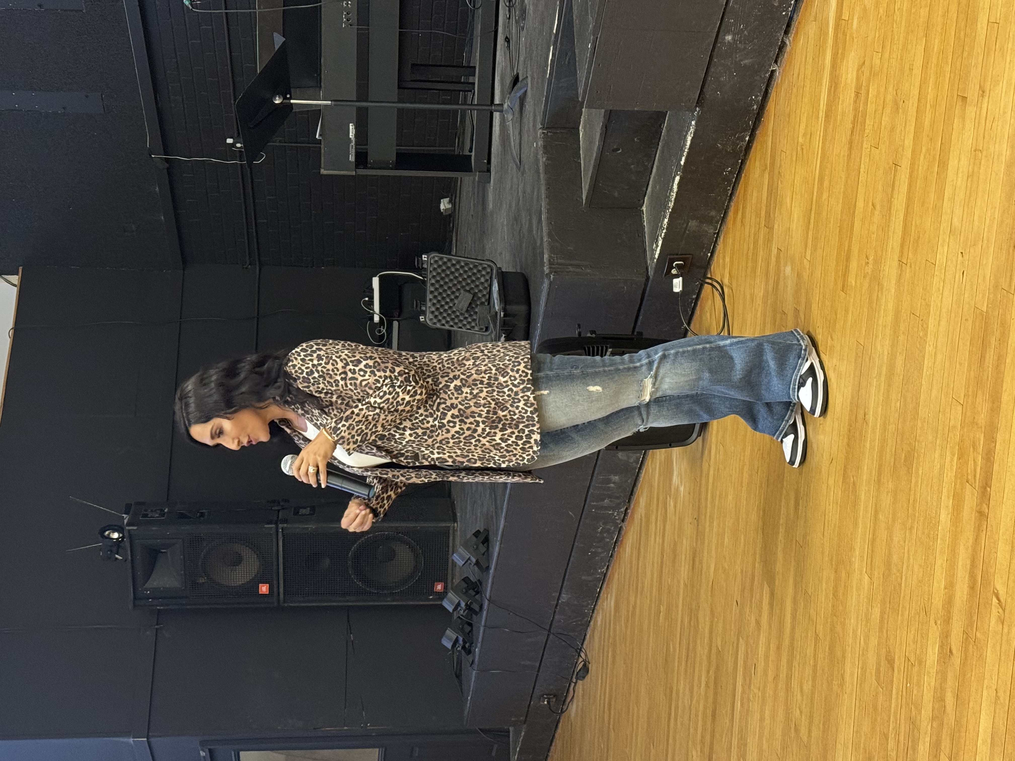Mandy Reed speaking with a handheld microphone in a community gathering space